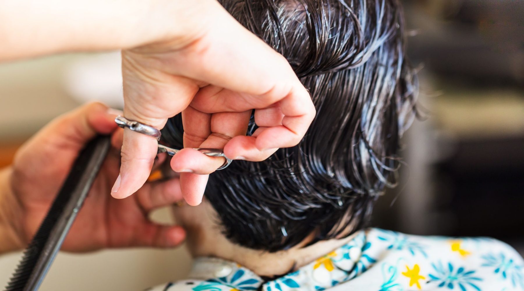 Nahaufnahme einer Friseurin beim präzisen Schneiden einer Haarsträhne