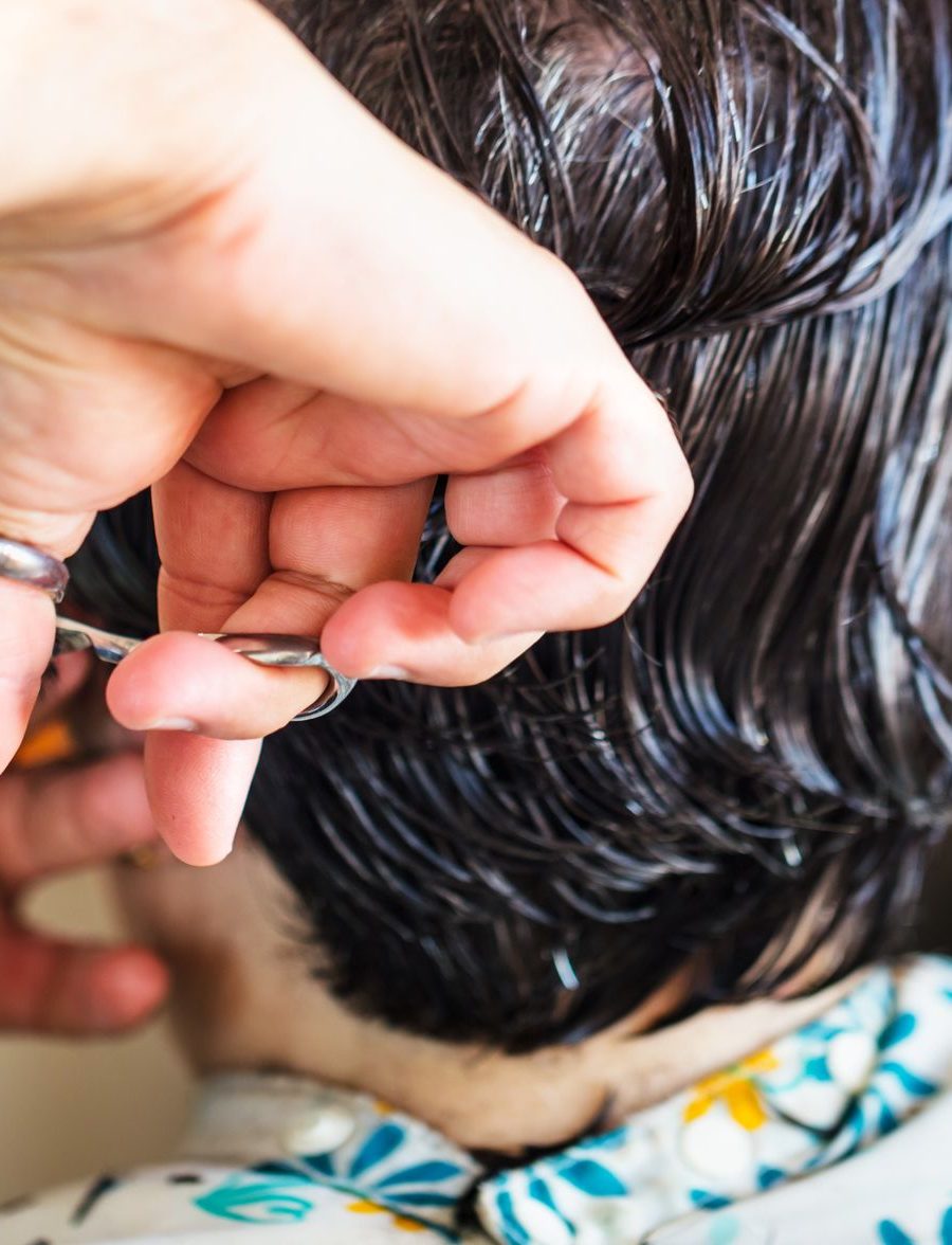 Nahaufnahme einer Friseurin beim präzisen Schneiden einer Haarsträhne