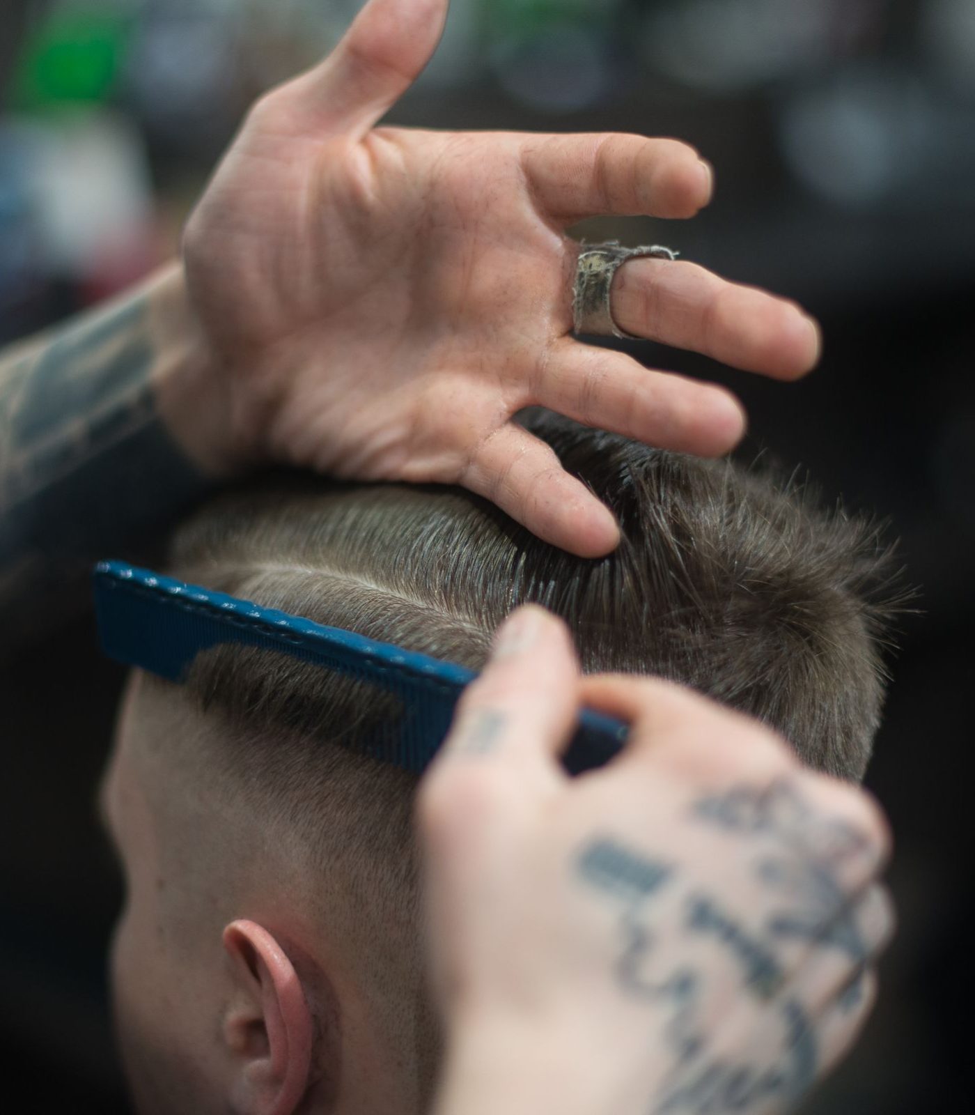 Friseur kämmt und schneidet präzise die Haare eines Kunden